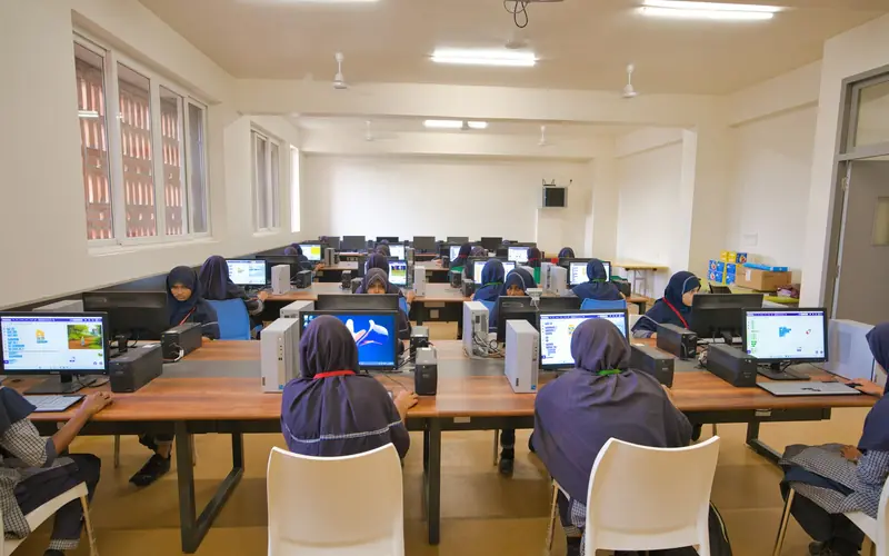 Students learning at desktop computers in a computer lab.